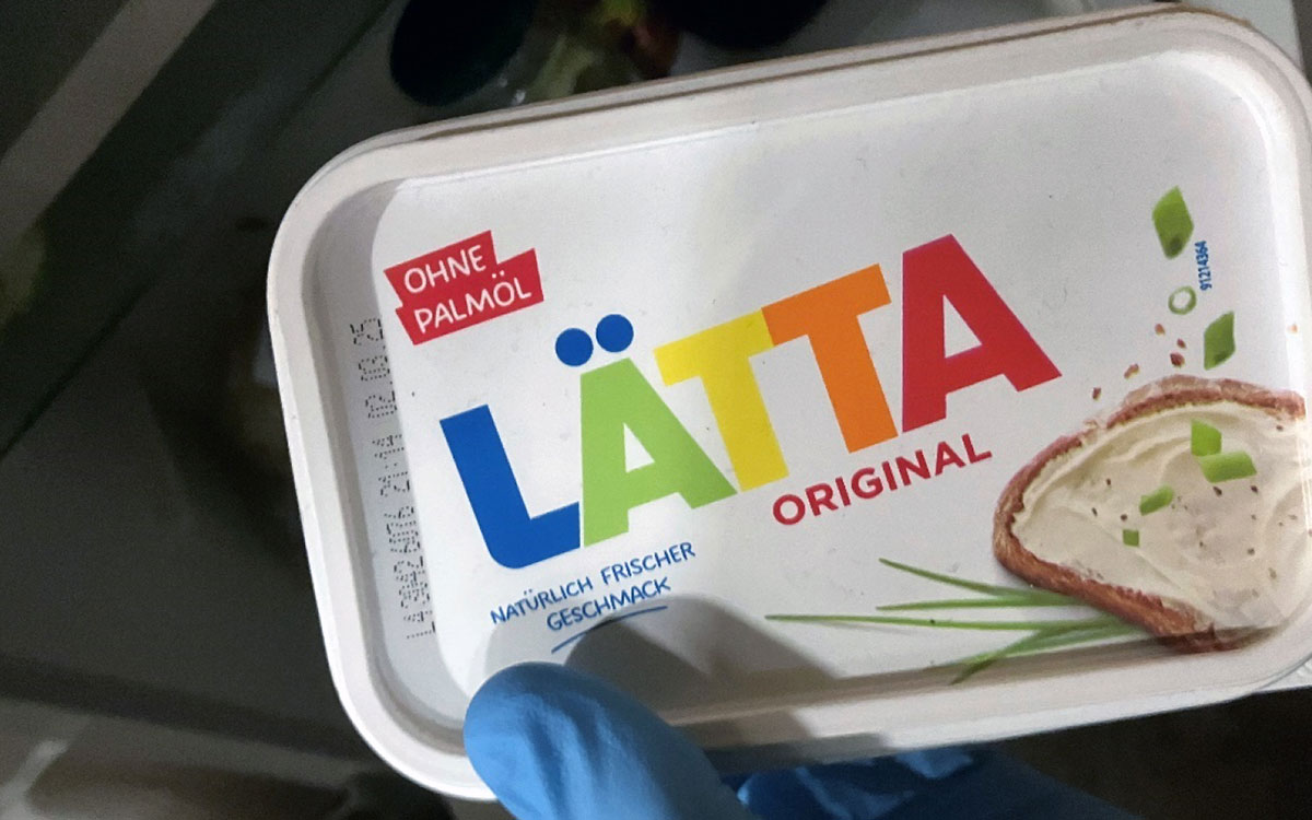 En handsbeklädd hand som håller i ett paket med Lätta.