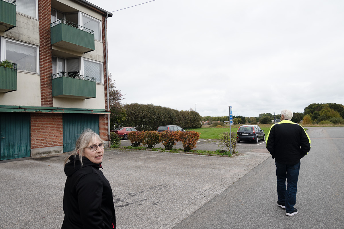 En kvinnan som tittar bakåt. På en gata i ett bostadsområde.
