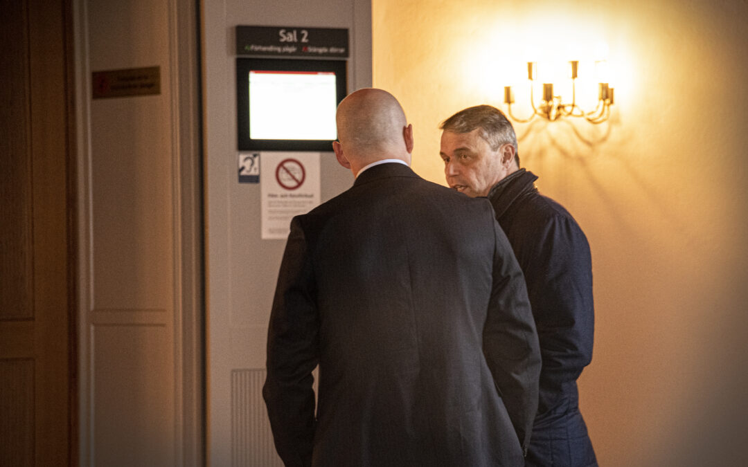 Två män i kostym i förtroligt samtal.