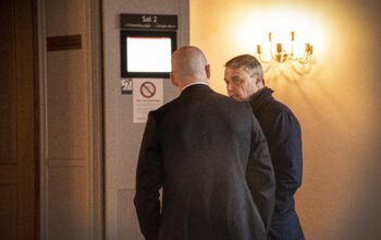 Två män i kostym i förtroligt samtal.