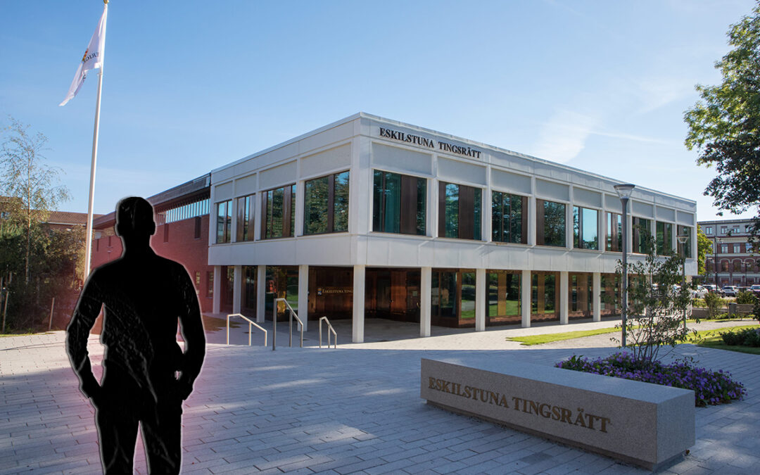 Svart silhuett av en man. I bakgrunden en vit, modern byggnad med stora fönster.