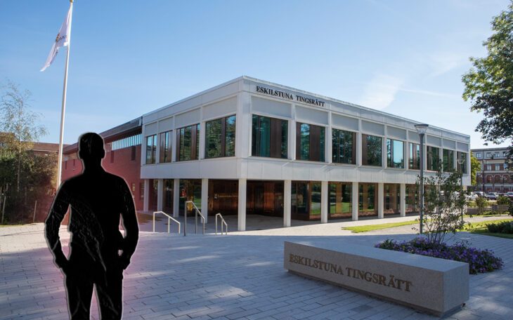 Svart silhuett av en man. I bakgrunden en vit, modern byggnad med stora fönster.