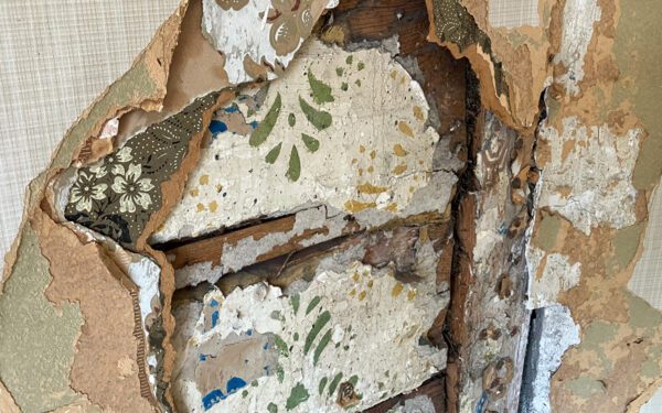 En vägg med lager av olika lager av tapeter, från 1960-tal till 1800-tal.