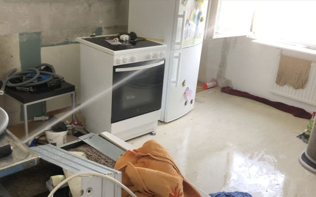 Vatten sprutar från rör ut genom fönster.