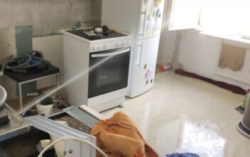 Vatten sprutar från rör ut genom fönster.