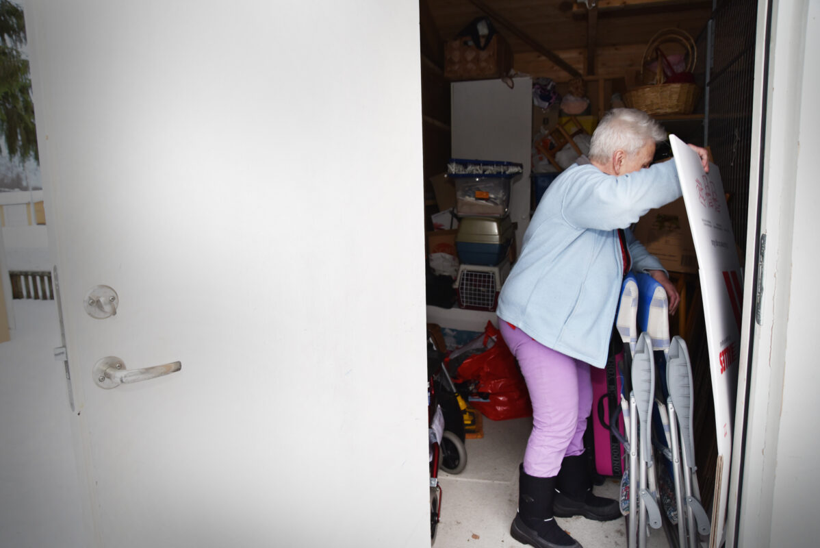 En äldre kvinna som stökar i ett förråd.