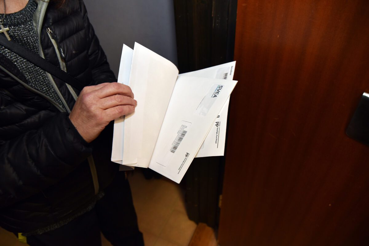 Bild med en person som håller i oöppnad post från inkasso.