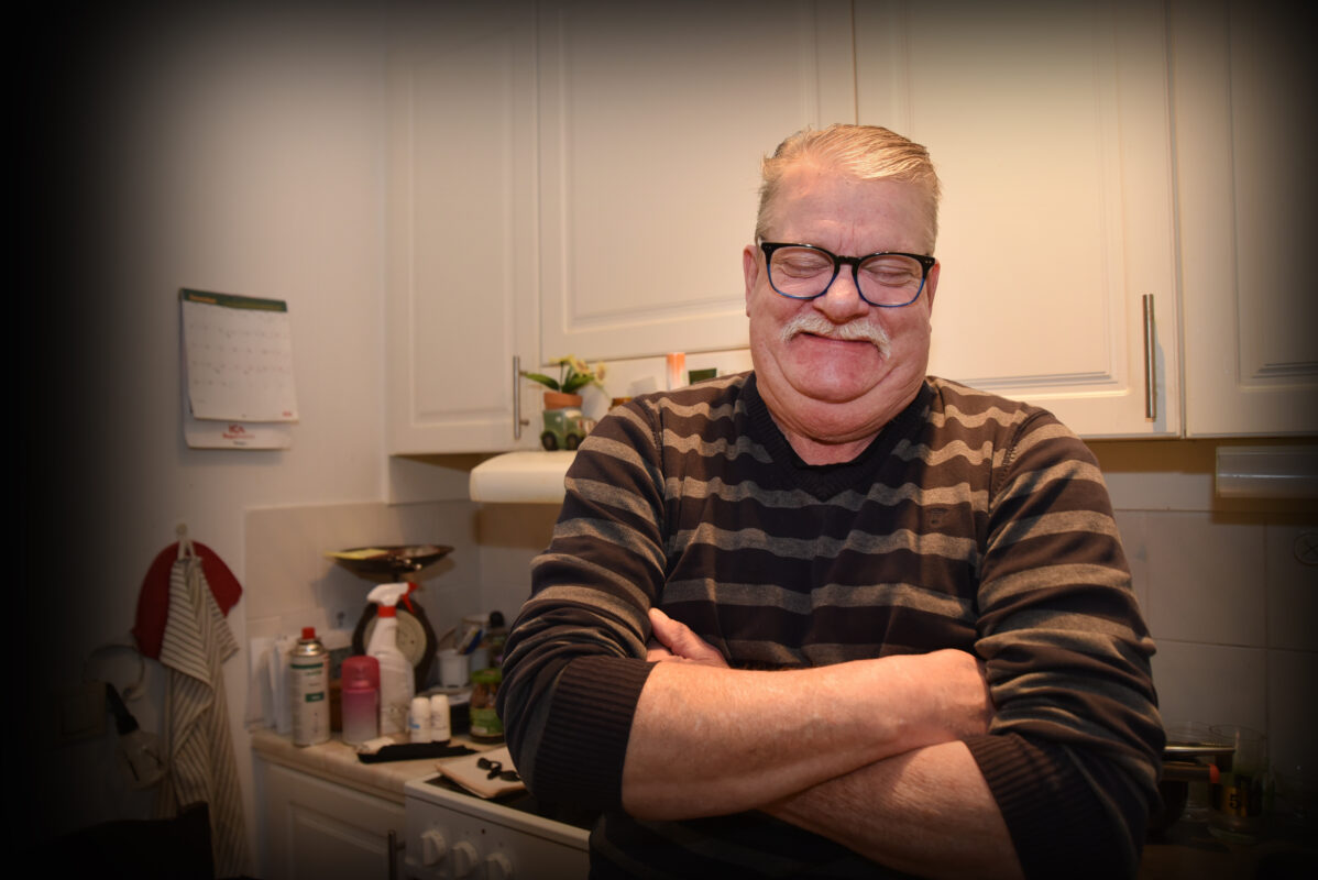 En äldre man med förnöjd uppsyn som blundar med korsade armar. 