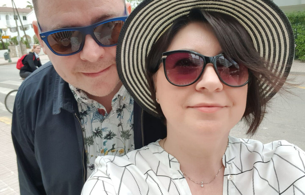 En tjej och en kille i solglasögon. Tjejen har en solhatt.