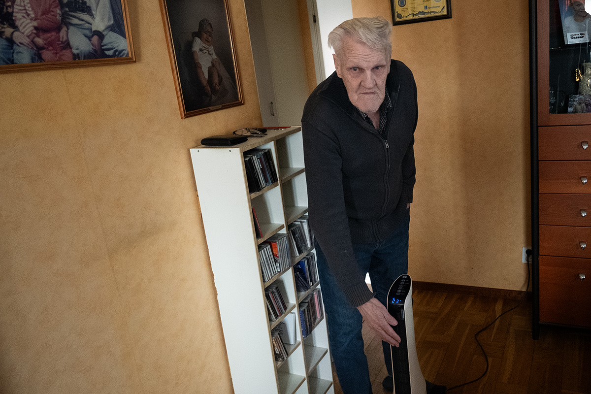 En man som känner på en portabel värmefläkt.