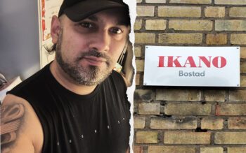 En tudelad bild. Den till vänster är en närbild på en man i 30-årsåldern. Han har svart keps och svart t-shirt- Bruna ögon, gråsvart skägg och några lockar i nacken. Han tittar allvarligt in i kameran. T h: Ikanos skylt i rött och vitt på en gul tegelvägg.