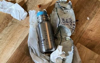 En tejpad termos i mannens lägenhet. Texten "polis potatis gris" syns utanpå.