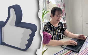 Till vänster en bild på Facebooks tumsymbol. Till höger en äldre kvinna vid ett köksbord. Hon har kortklippt mörkt hår, glasögon och en kortärmad blus i randigt mönster. Hon skriver på en laptop. Under datorn är en randig duk. I förgrunden skymtar en lila tulpan.