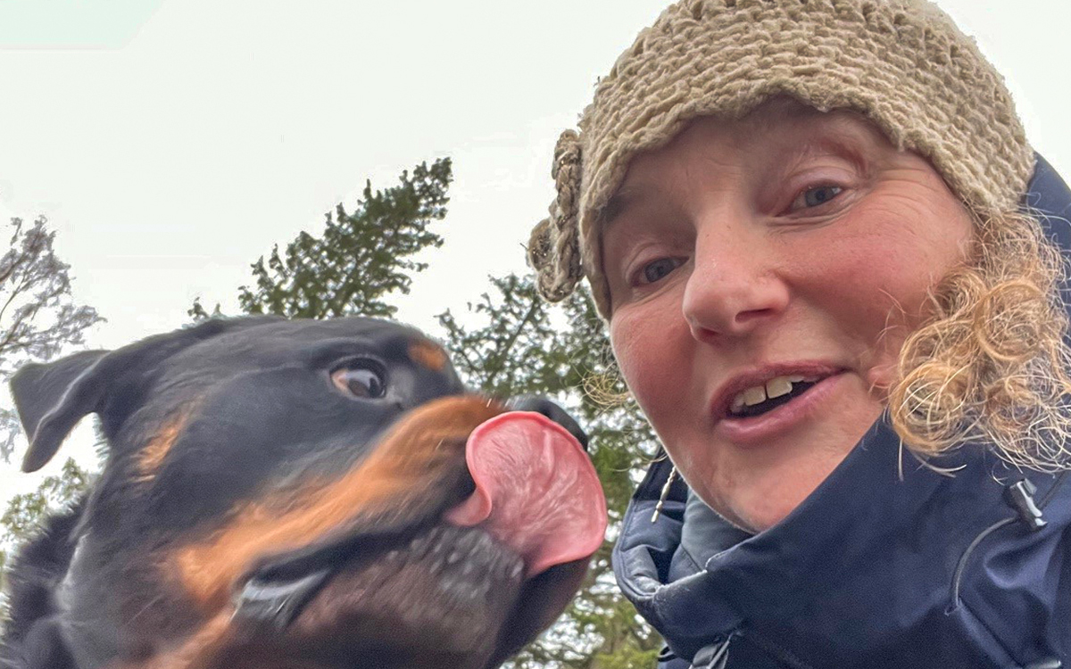 En närbild på en kvinna samt en hund med tungan utanför munnen.