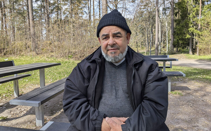 En bild på en man i 70-årsåldern. Han sitter vid ett träbord ute med en skog i bakgrunden. Han har svart mössa, lite skäggväxt och har händerna knäppta framför sig. han tittar allvarligt in i kameran. Han har svart mössa, svart jacka och grå tröja. Uppsalahem har infört en tipsfunktion för att komma åt otillåten andrahandsuthyrning.