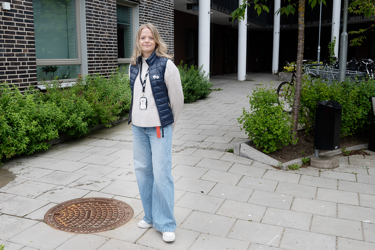En kvinna som står utanför ett hus.