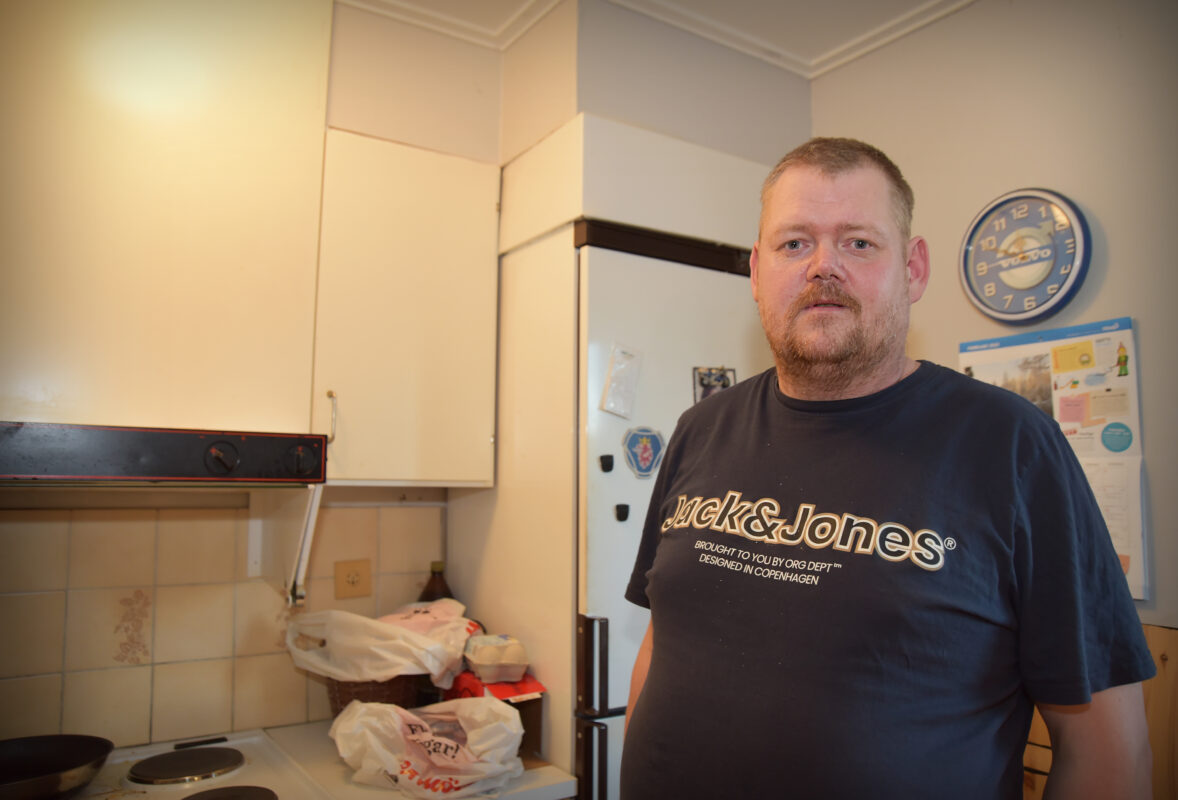 En bild på en medelålders kille i svart T-shirt som står i ett kök.