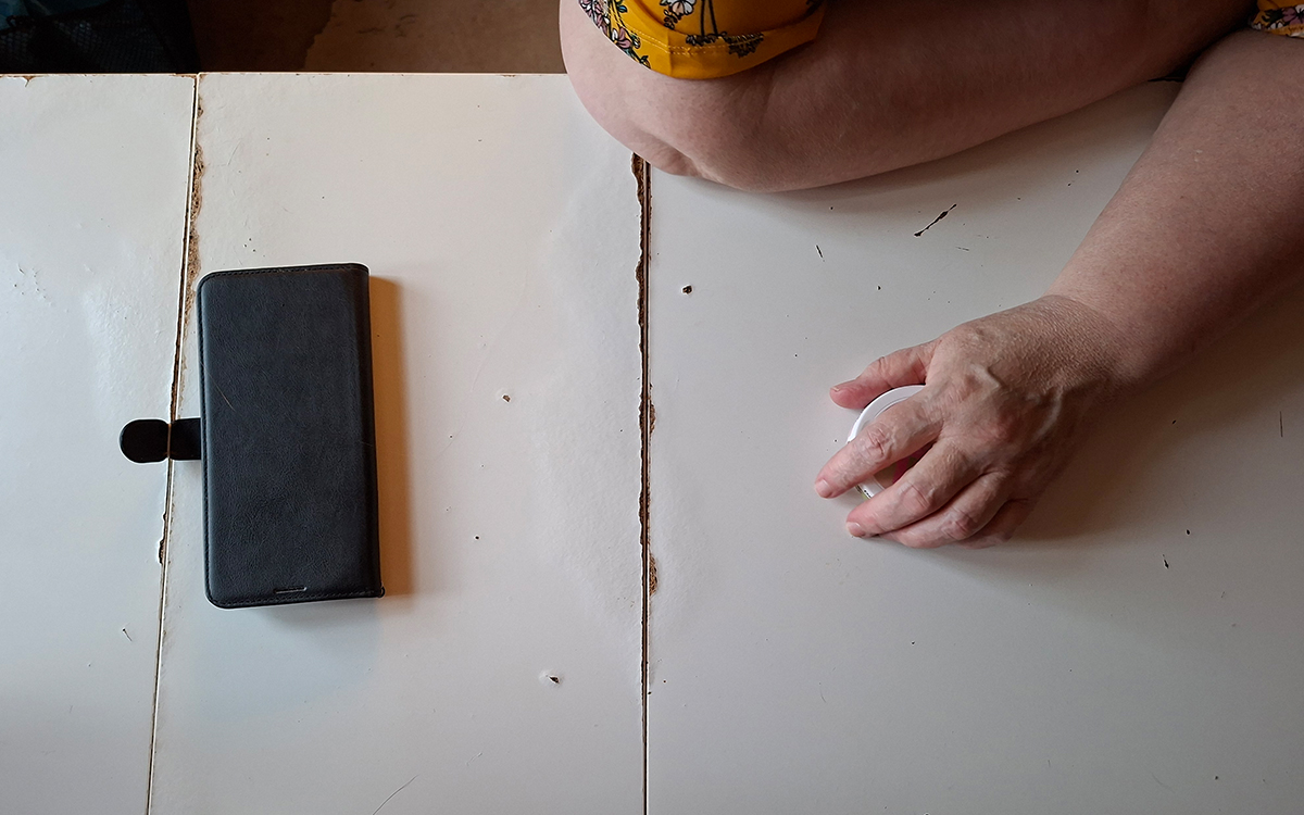 Bilden visar en armbåge samt en hand på ett bord. Bilden är i svartvitt.