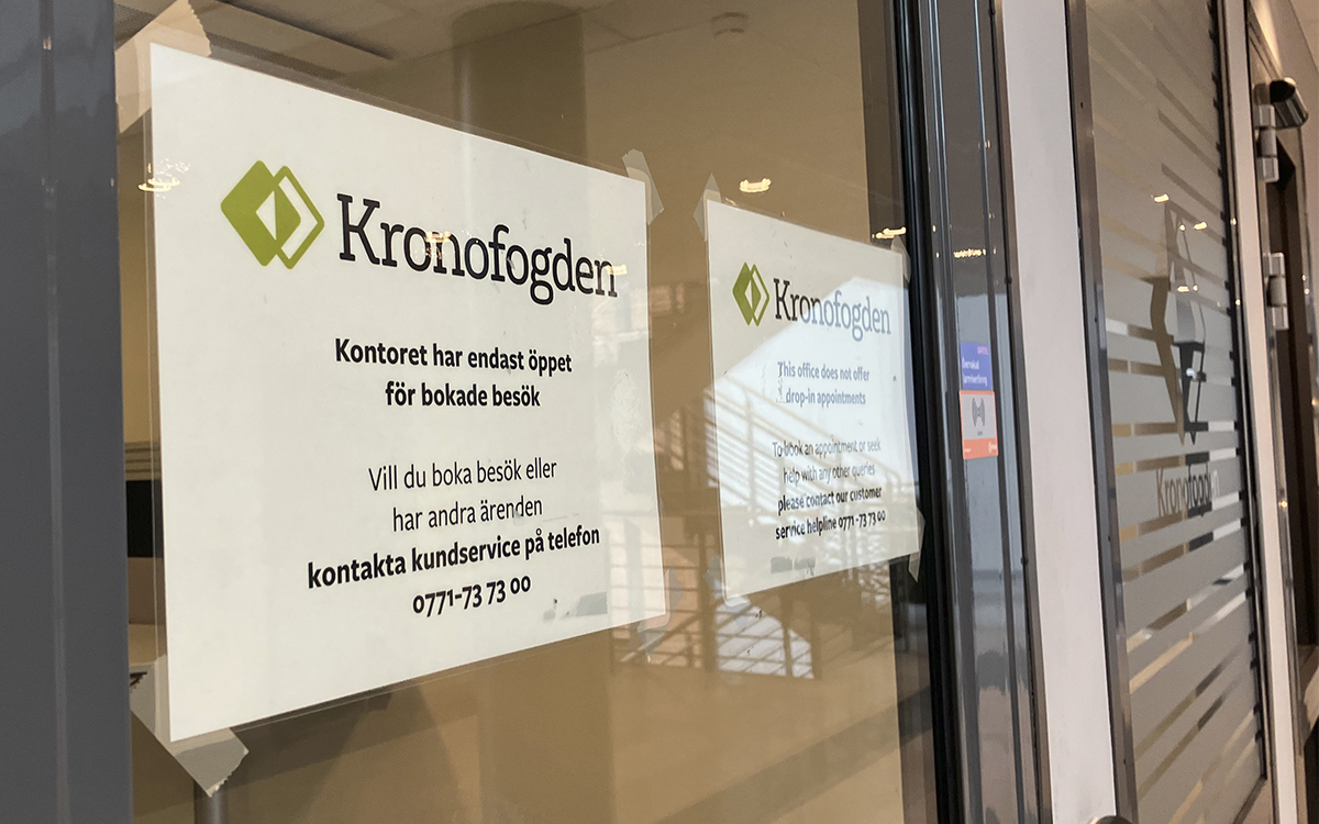 Upptejpade skyltar på glasdörren till Kronofogdens kontor i Uppsala. Kronofogden gör ett nytt försök att sälja några av AB-hems hyreshus i Sala.