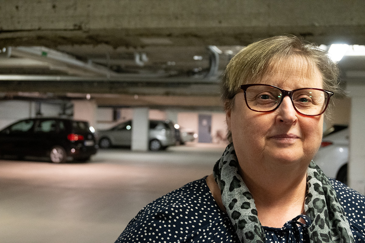 En närbild på en kvinna som står i ett garage.