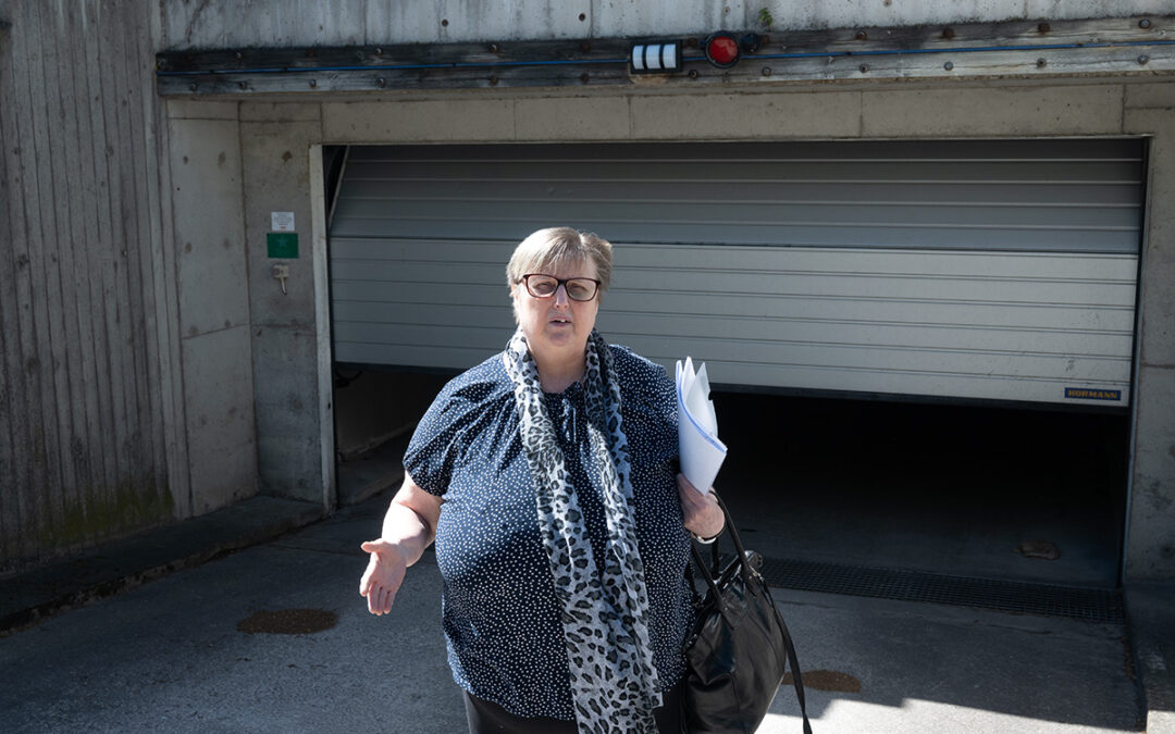 En kvinna som står framför utgången till ett garage.