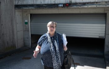 En kvinna som står framför utgången till ett garage.