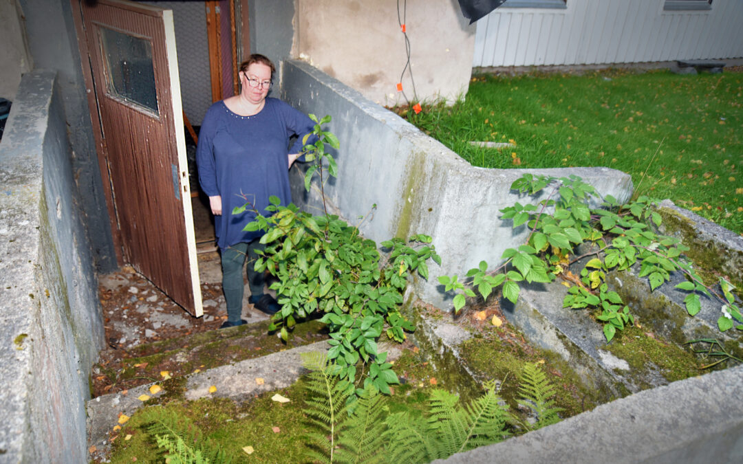 En kvinna i en stentrapp som är mossbeklädd och överväxt.