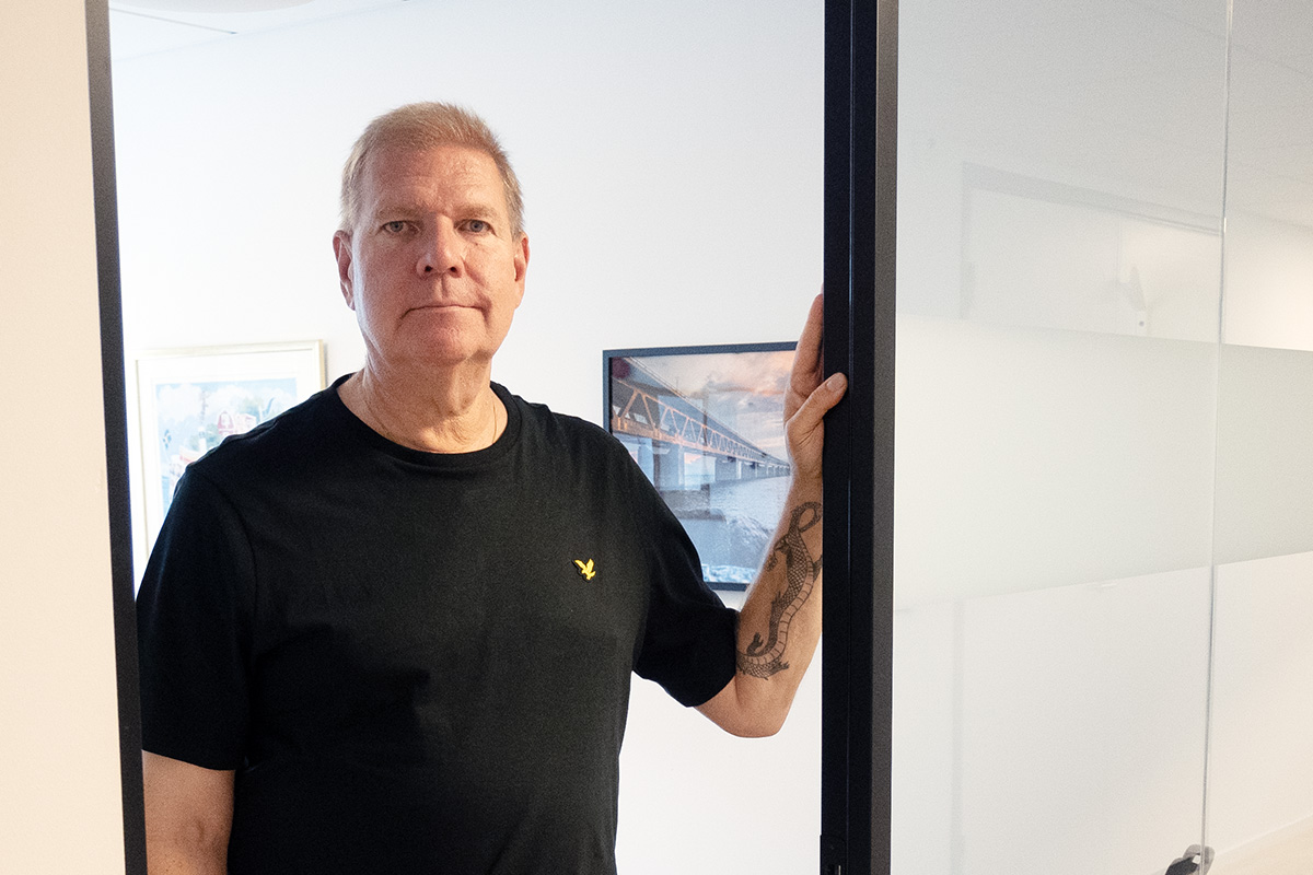 En man i svart t-shirt som står i en dörröppning.