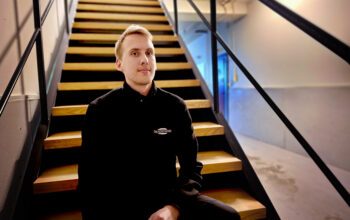 En man som arbetar som skadetekniker sitter i en trappa.