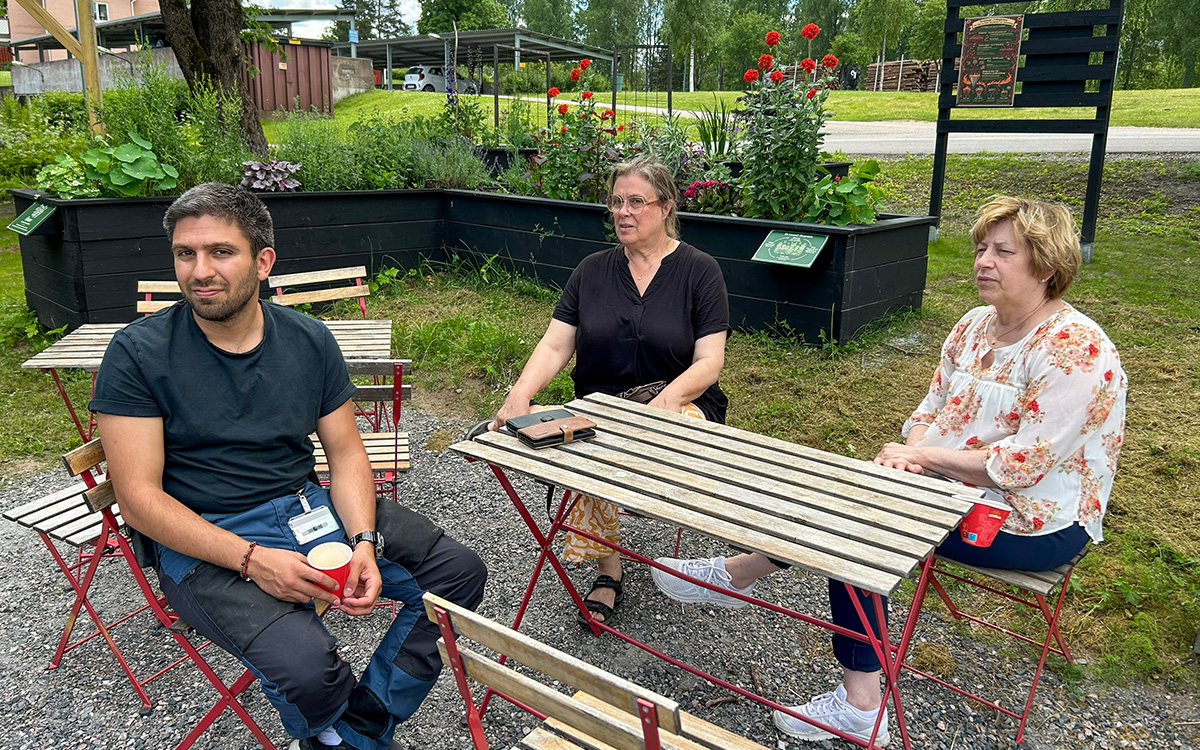 En man och två kvinnor sitter vid ett bord utomhus.