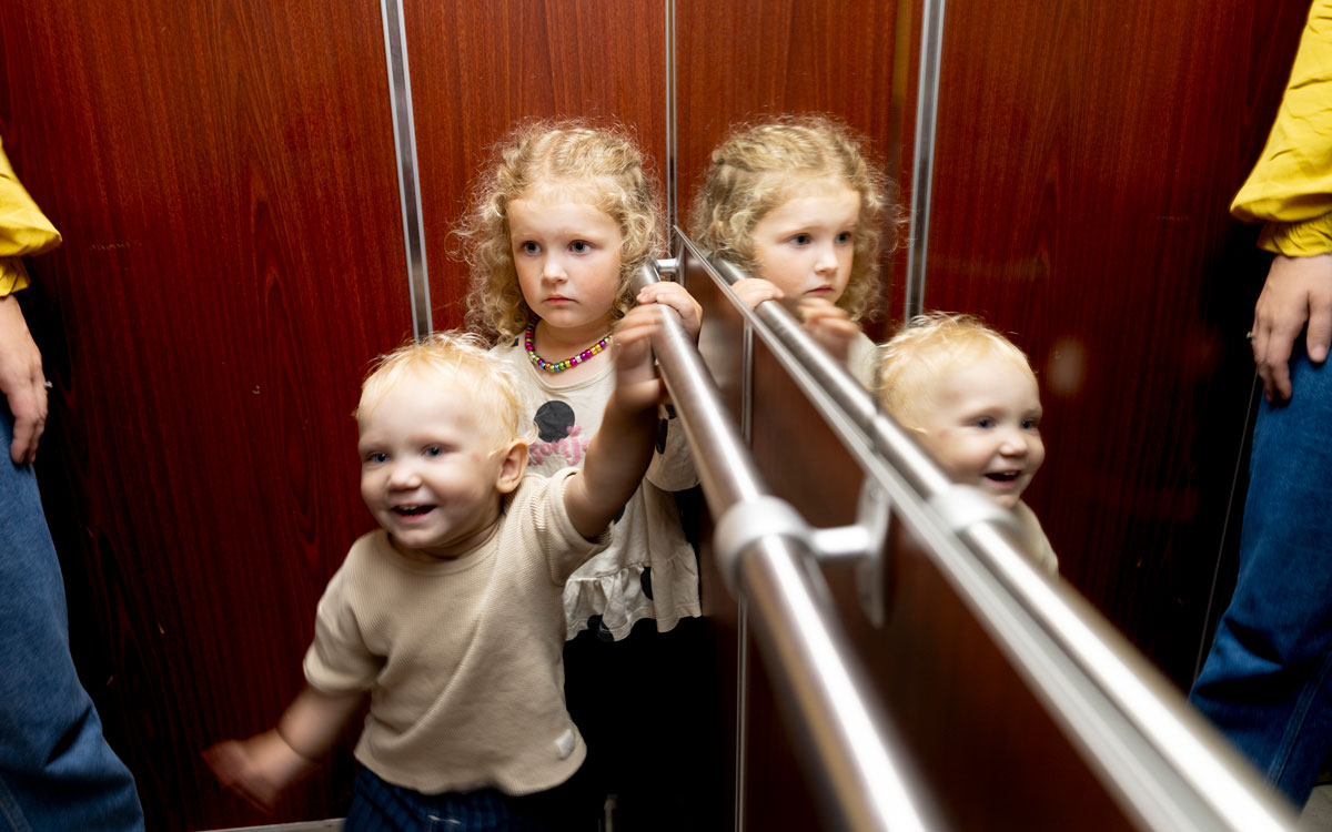 Samuel, 1 år, och Malou, 3 år, åker hiss hemma i Lund.