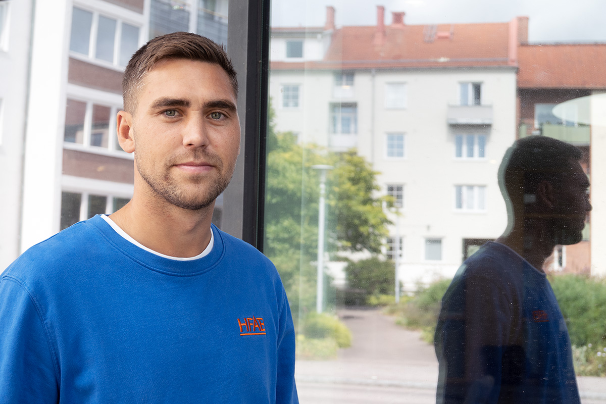 En man i blå tröja som tittar rakt fram.