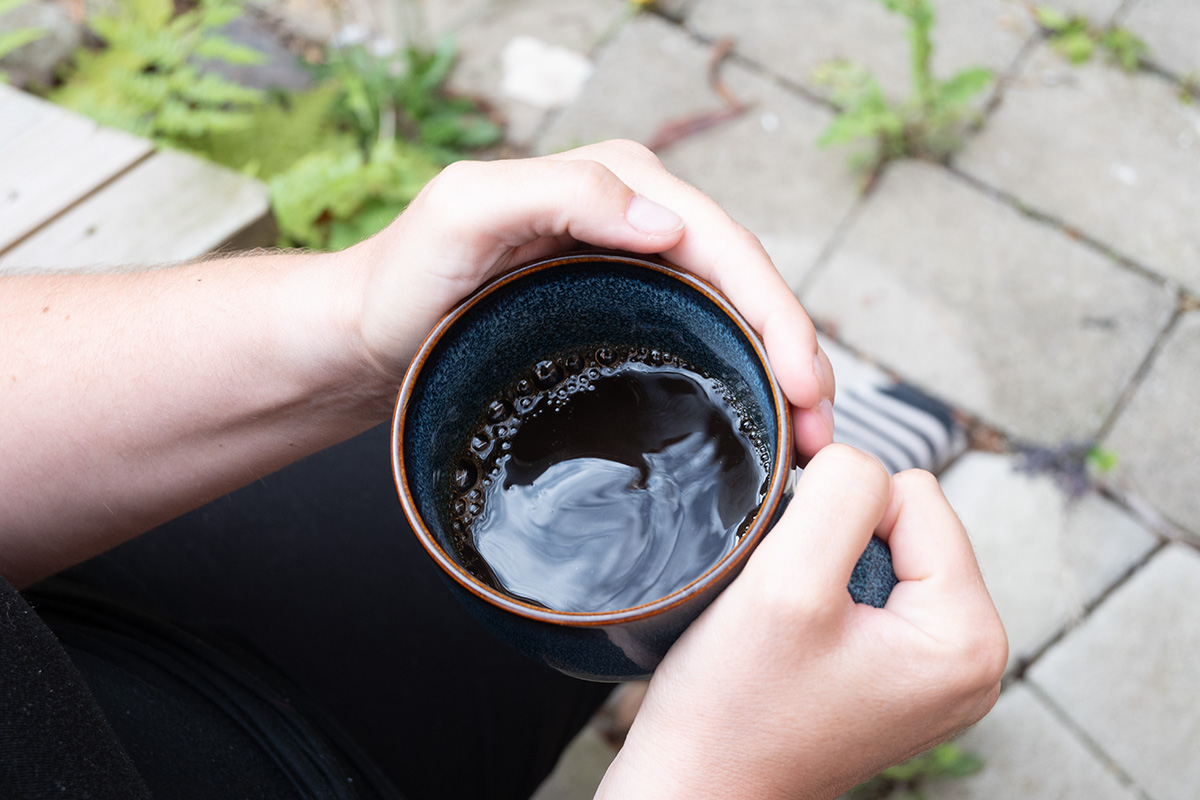 Händer som omsluter en kaffekopp.