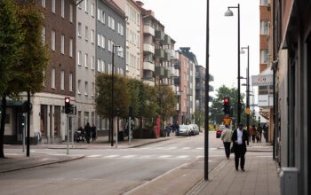 En vy över en stadsgata med flervåningshus på båda sidor.