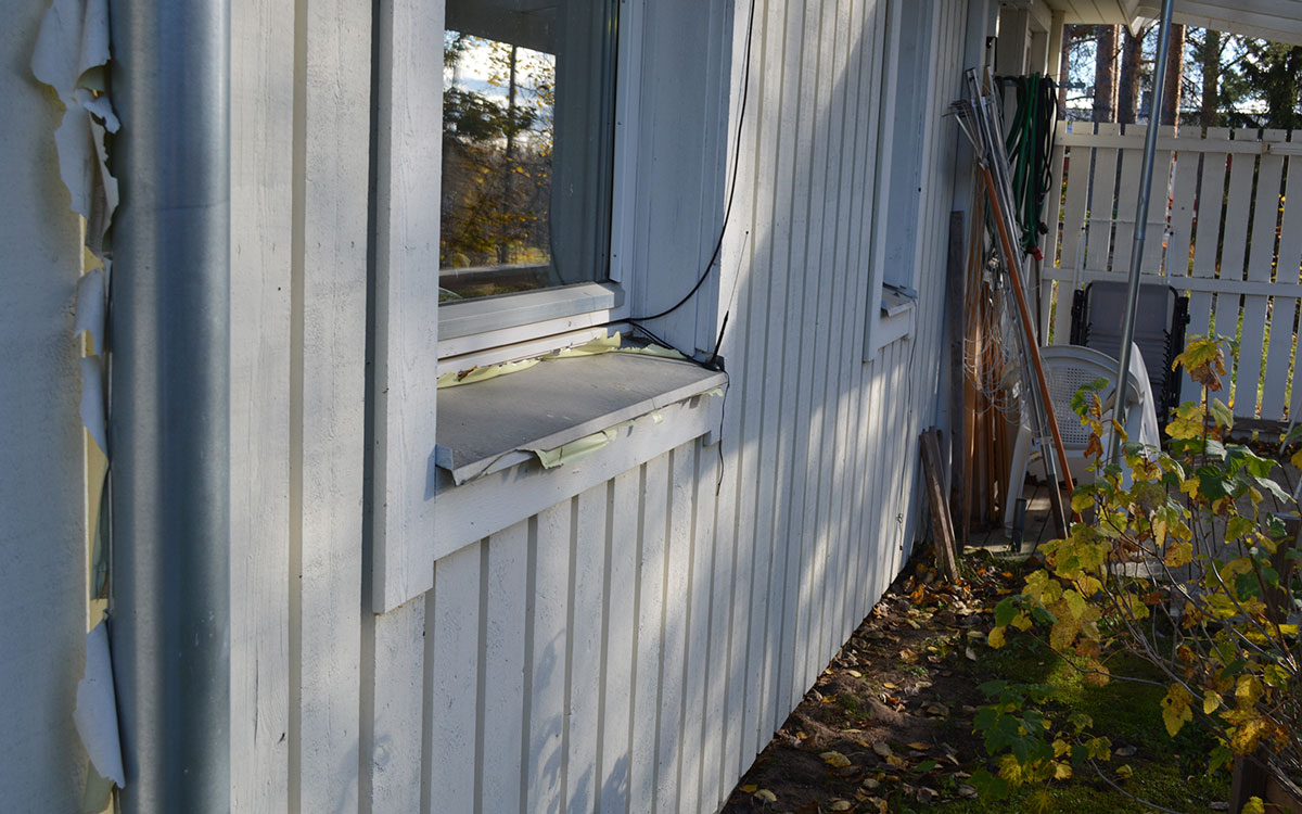 Plastfärg som flagnat på husen i Fällfors.