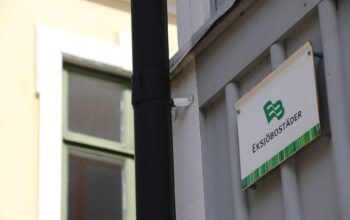 Skylt med Eksjöbostäder uppsatt på en husfasad.