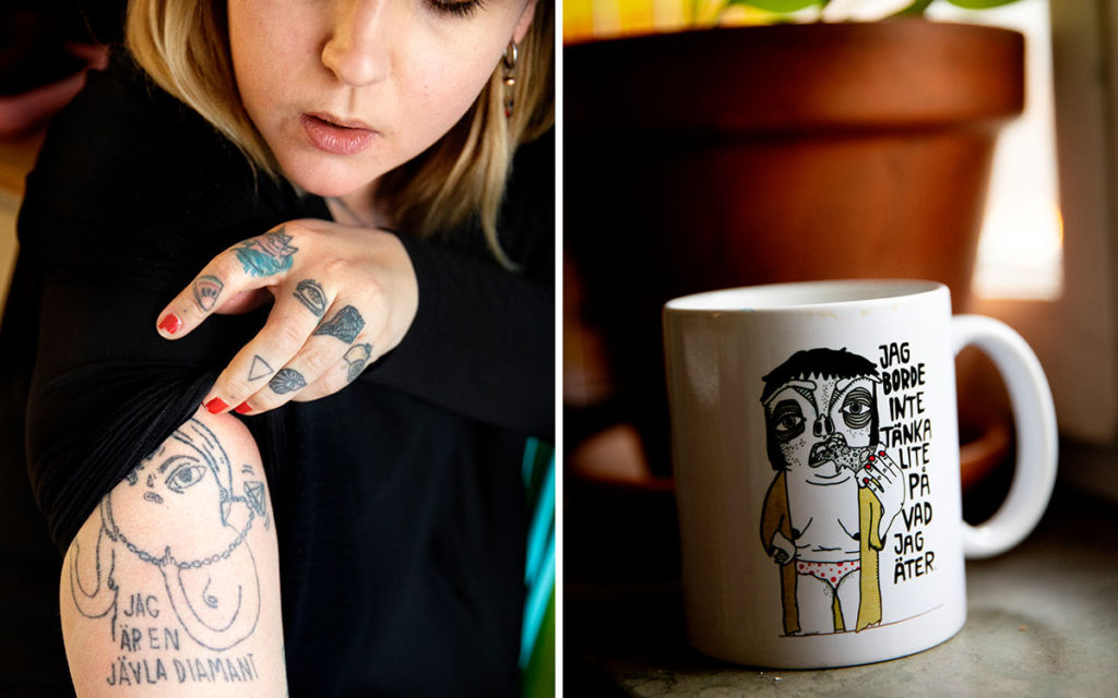 Charlotta Björck visar upp sin armtatuering och en mugg där hon själv står för illustrationen.