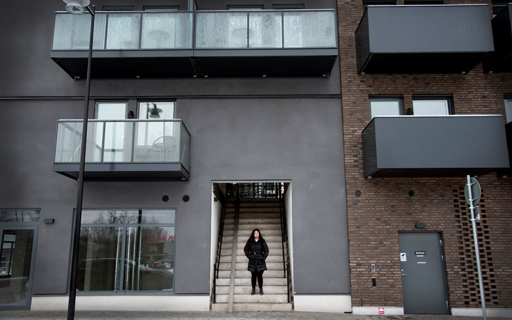 Blockuthyrningens baksida. Tania Kashkol står i trappan till innergården i Häggvik.