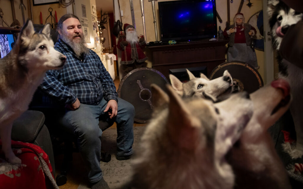 Carl Mikael Bengtsson och hans hundar hemma i vardagsrummet.