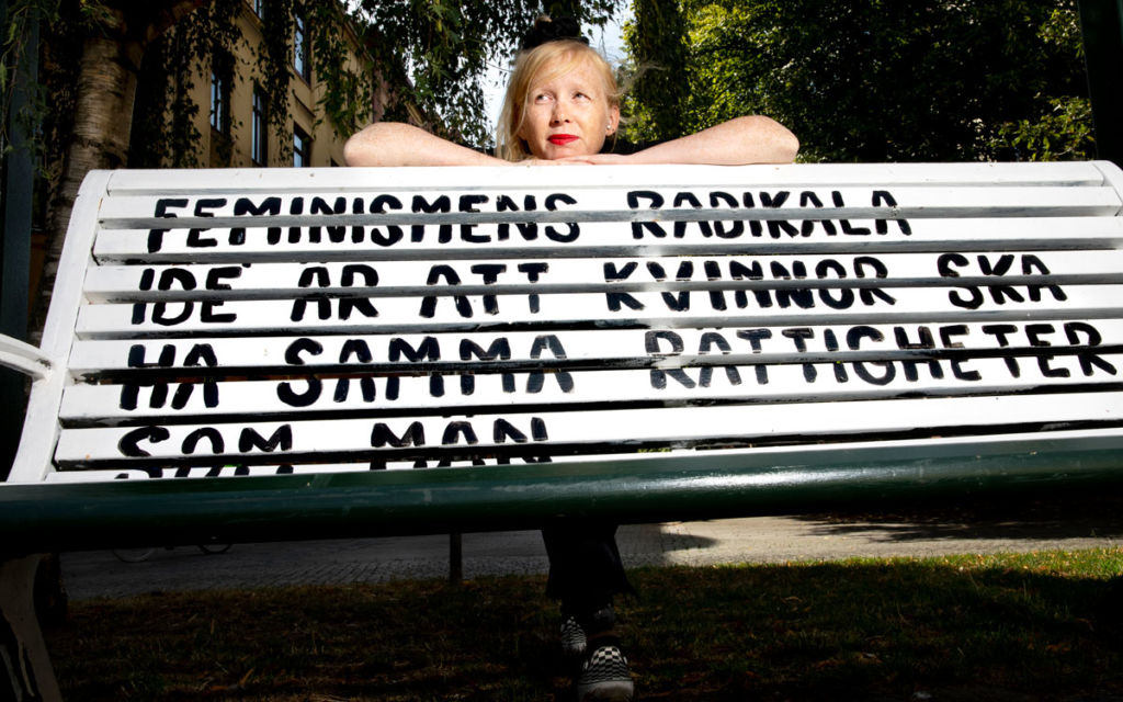 Jessica Hallbäck vid parkbänken hon målat. Den står i Knarkrondellen på Möllan i Malmö.