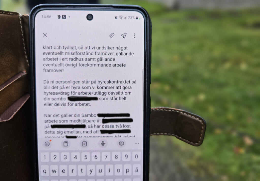 Bilden visar en mobil med ett sms där vissa namn är överstrukna med svart.