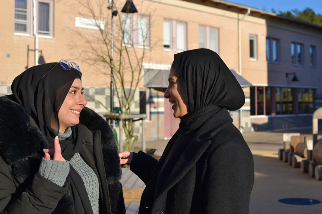 Yusur Al-Mohamedi och Tala Harb utanför sin gamla skola i Lövgärdet. ”Vi är inte naiva, vi vet att det finns problem här. Jag är stolt storasyster till en lillebror som utsatts för rektyreringsförsök av gängen. Men han säger nej, han tränar stenhårt och sitter hemma och gör läxor i stället. Det är så viktigt att unga har något att göra, att det finns aktiviteter”, säger Yusur Al-Mohamedi.